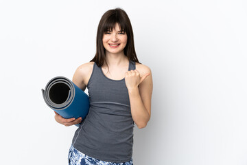 Ukrainian sport girl with mat isolated on blue background pointing to the side to present a product
