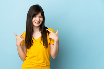 Teenager Ukrainian girl isolated on blue background giving a thumbs up gesture