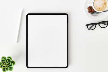Top view of blank screen tablet on white working desk