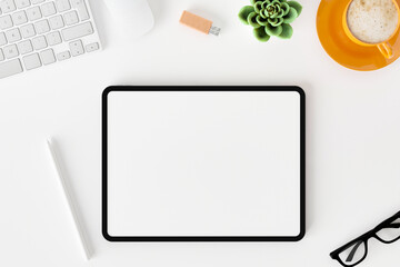 Top view of blank screen tablet on white working desk