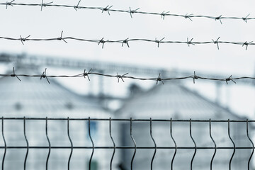 Barbed wire protects the granary. A large modern agro-processing plant blurred. (concept: food...