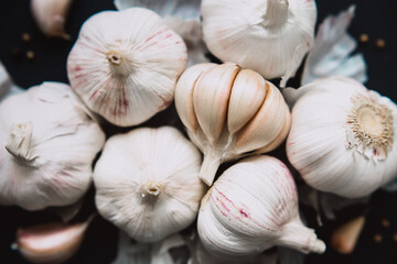 Garlic bulbs on black background, close-up. Organic garlic top view. Food background. Selective focus.	
