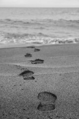 Footprints on the sand beach and a mysterious way to the ocean.