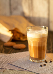 Glass with coffee latte and cookies in the sunset light
