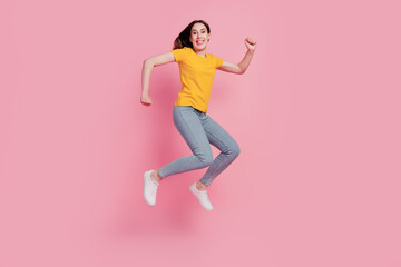Fototapeta na wymiar Photo of cheerful relaxed brunette woman jump run go shopping wear casual jeans clothes on pink background