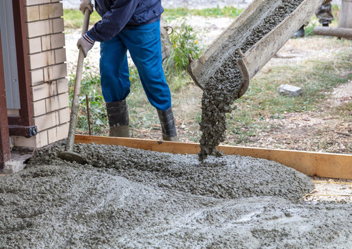 Workers level out the concrete mix at a construction site.