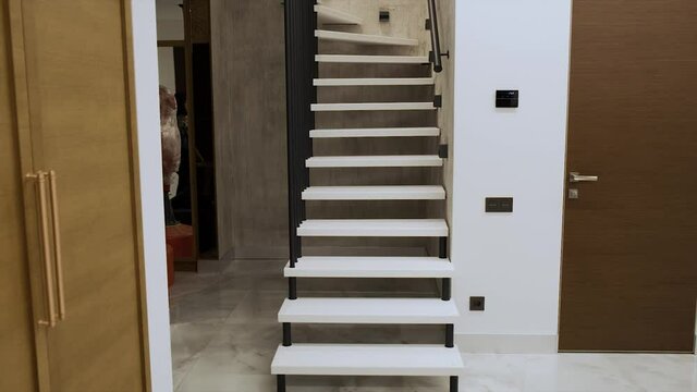 Interior photography. White spiral staircase with metal railings in a duplex apartment.