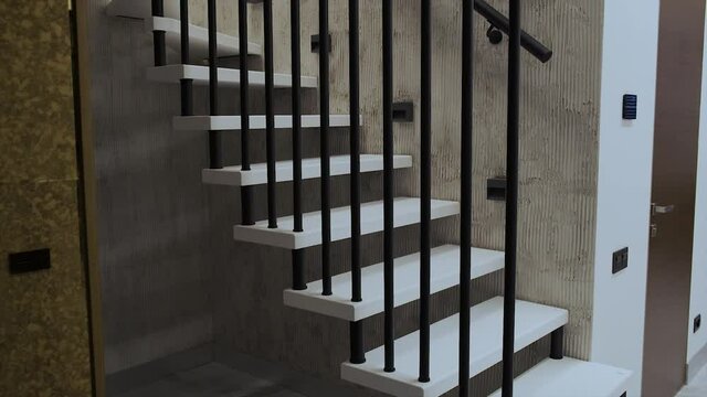 Interior photography. White spiral staircase with metal railings in a duplex apartment.