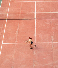 The girl plays tennis on the court. Sport