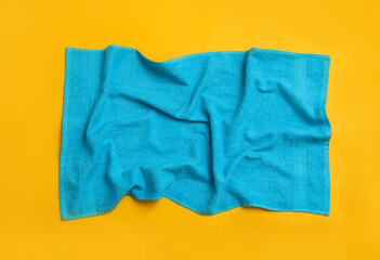 Fototapeta na wymiar Crumpled light blue beach towel on yellow background, top view