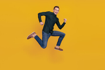 Fototapeta na wymiar Full length profile side photo of young cheerful man have fun jump go run sale isolated over yellow color background