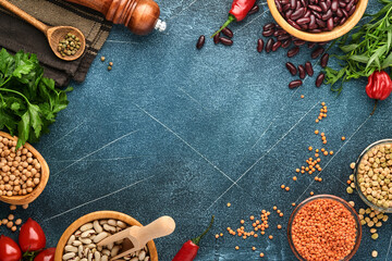 Legumes, lentils, chickpea, beans assortment, tasty appetizing ingredients spices grocery for cooking healthy kitchen on black table. Weight loss diet and fight against cholesterol concept. Top view.