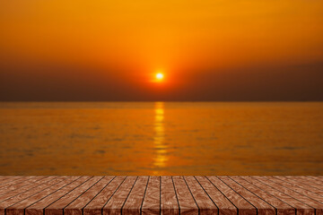 Empty wooden table on beautiful blurred sea sunset