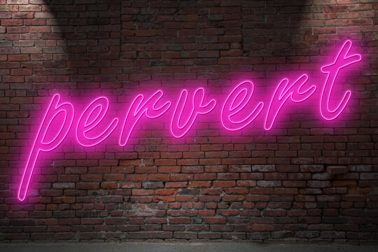 Neon pervert lettering on Brick Wall at night