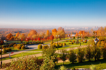 Top down photo in autumn showing the beautiful fall autumn colours of a park near Planetarium and city in fog on background in Novosibirsk