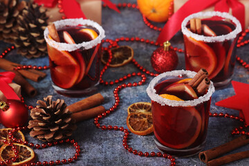 Three glasses with mulled wine with fruits and cinnamon sticks
