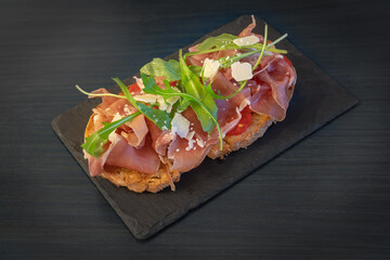 Sandwich with ham, cheese, tomato and salad. On the stone plate. Close up