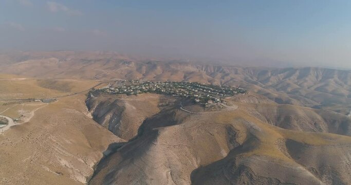 Jewish settlement at the desert of Judea and Samaria in Israel . Aerial view drone shot of village Houses on top hill mountains view. Outdoor Mediterranean coexist living