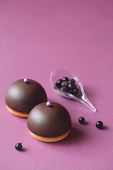 Mini Dome Cakes - Ptichye Moloko (Bird's Milk) - traditional Russian (Soviet) Souffle Cake, with black currant filling, covered with chocolate glaze, on purple background