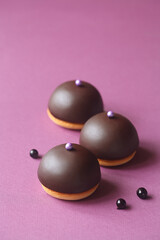 Mini Dome Cakes - Ptichye Moloko (Bird's Milk) - traditional Russian (Soviet) Souffle Cake, with black currant filling, covered with chocolate glaze, on purple background