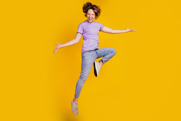 Fototapeta na wymiar Photo of triumphant crazy man jump dance enjoy fun flight wear casual jeans clothes on yellow background