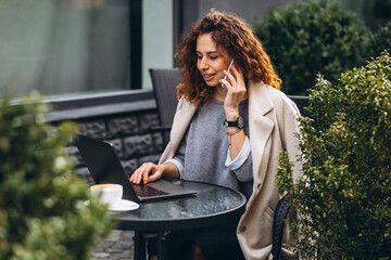 Young business woman working on a computer outside the cafe