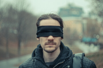 a man with a black blindfold over his eyes