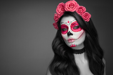 Portrait of a woman with sugar skull makeup over black background. Halloween costume and make-up. Portrait of Calavera Catrina