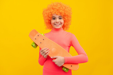 Happy girl scater with orange hair in pink poloneck smile holding pennyboard, skateboarding