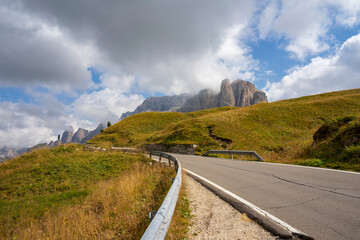 Mountain road on the background of the Sella massif. Dolomites. Italy.