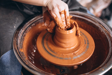 Female hands close up shaping clay pot