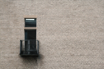 prosta ceglana ściana z czarnym balkonem