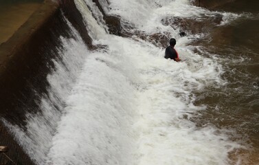 man in the middle of waterfall