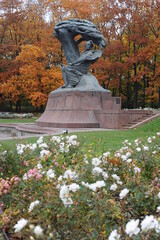 Frederic Chopin statue monument in Lazienki (Royal Baths) Park in Warsaw, Poland in autumn with foilage on the trees