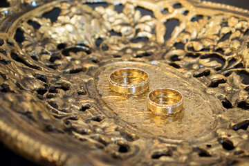 golden wedding rings on a golden plate 