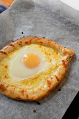 A ready-made dish of Georgian cuisine on a baking sheet. hot baked khachapuri boat