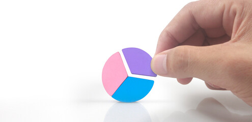 Business connecting piece of multi colored pie wood chart in hand