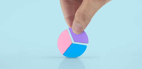 Business connecting piece of multi colored pie wood chart in hand