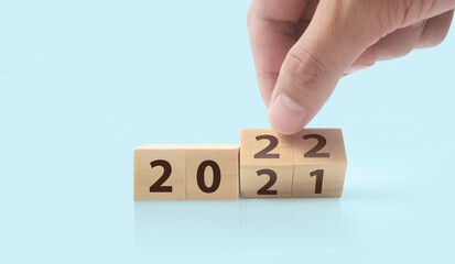 The hand puts  wooden cube with the letter  from the word. wooden cubes standing  in hand