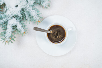 Obraz na płótnie Canvas Christmas composition. Fir tree branches, cup of coffee on snow background. Christmas, winter, new year concept. Flat lay, top view, copy space.