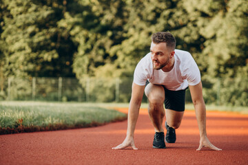 Man athlete jogging at stadium in the morning