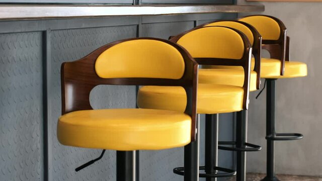 Close up of empty yellow bar retro chairs outdoor.