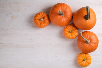Close up shot of a classic orange and baby boo pumpkins on wood textured table background as a symbol of autumnal holidays with a lot of copy space for text.