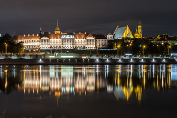 Fototapeta na wymiar The Royal Castle at night from the Vistula, Warsaw