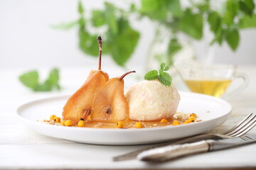 Poached pears with ice cream and mint on white background