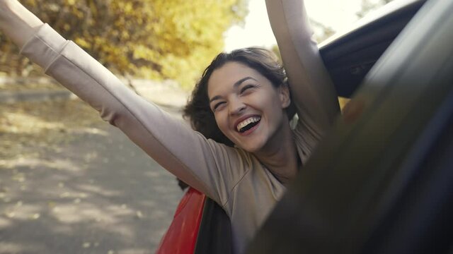 Cheerful woman leaning out of car window