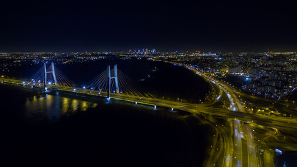 Night panorama of Warsaw from above, the Siekierkowski bridge and downtown, photo from the drone,...