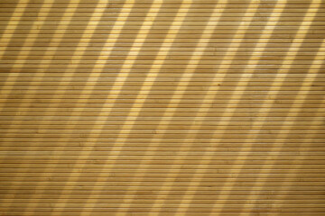 The wood is cut into strips that are arranged to form a wooden wall and the light shines through in the lines. Decorate the wallpaper.