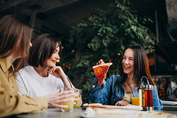 Girls friends having pizza at a bar at a lunch time