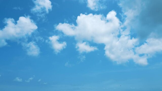 A timelapse of a blue sky and moving airy white clouds. Textures of white clouds forming against a blue sky background. Heavenly timelapse. Bottom-up view of the sky with fast-moving clouds.